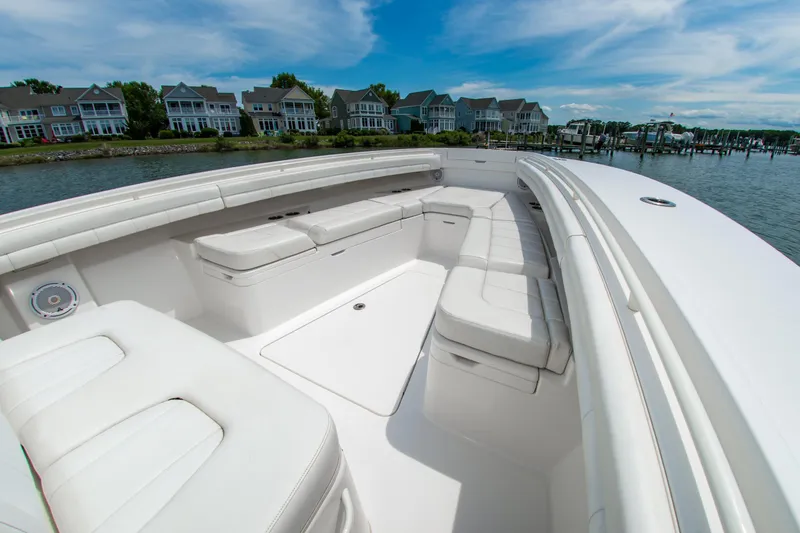 Slide: The Image of 2019 Regulator 31 boat with spacious white seating, docked near waterfront homes. - 32