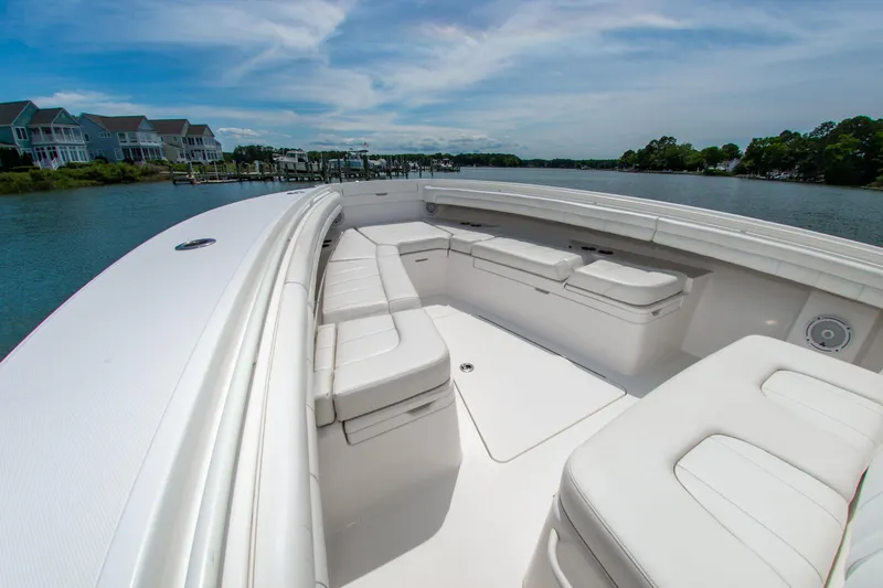 Slide: The Image of 2019 Regulator 31 boat with spacious seating, docked near waterfront homes under a clear sky. - 34