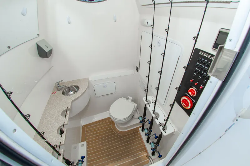 Slide: The Image of 2019 Regulator 31 boat interior with bathroom, sink, and fishing rod storage. - 37