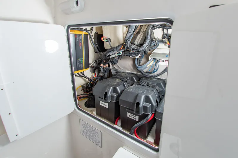 Slide: The Image of Electrical compartment of a 2019 Regulator 31 boat, featuring batteries and wiring. - 38