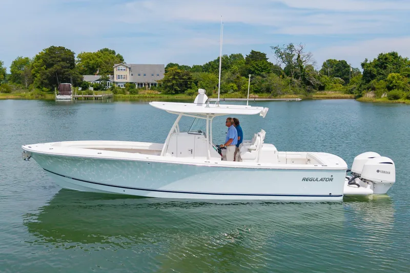 Slide: The Image of 2019 Regulator 31 boat on calm water with lush greenery in the background. - 41