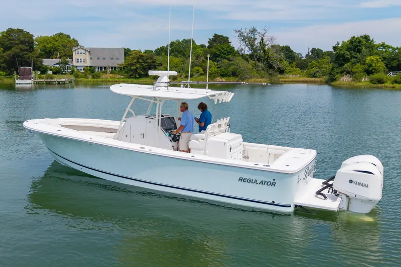 Slide: The Image of 2019 Regulator 31 boat on calm water with Yamaha engines, surrounded by lush greenery. - 42