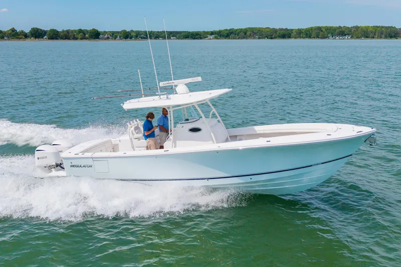 Slide: The Image of 2019 Regulator 31 boat cruising on open water with two people onboard. - 44