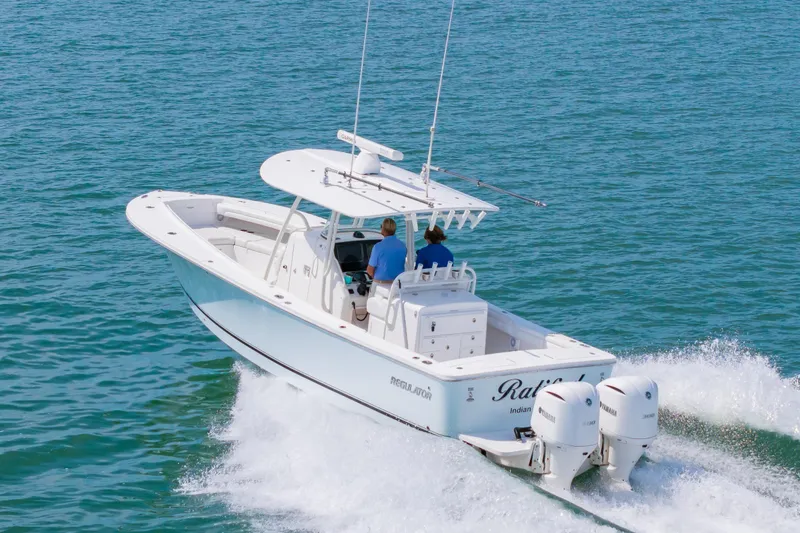 Slide: The Image of 2019 Regulator 31 boat cruising on open water with twin engines. - 54