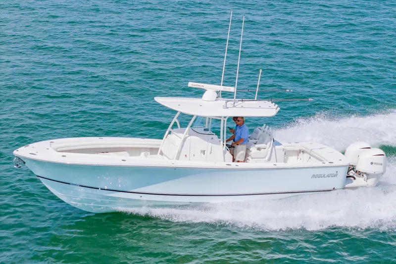 Slide: The Image of 2019 Regulator 31 boat cruising on clear blue water. - 56