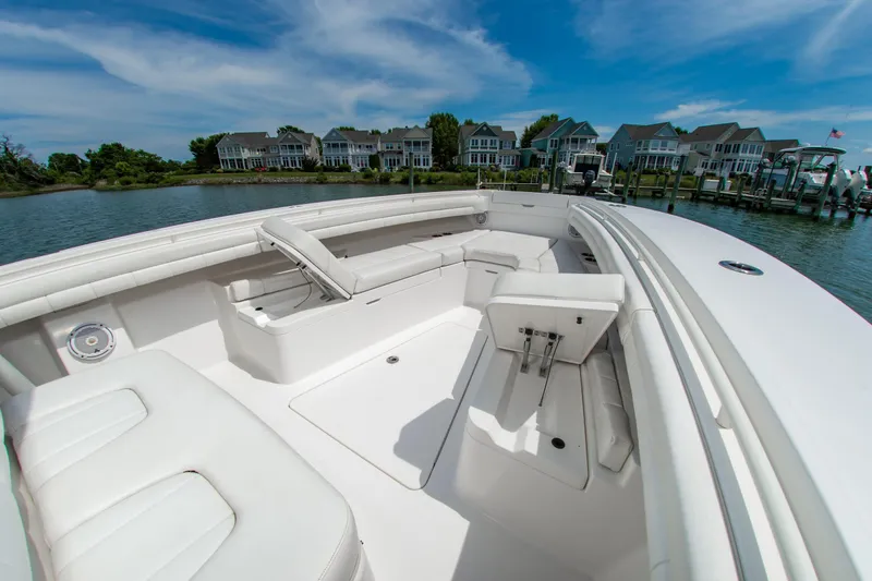 Slide: The Image of 2019 Regulator 31 boat interior with white seating, docked near waterfront homes. - 7