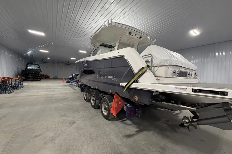 Slide: The Image of 2027 Regal 38 Surf boat in a spacious indoor storage facility. - 16
