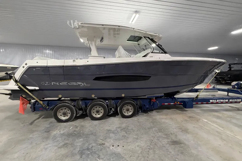 Slide: The Image of 2027 Regal 38 Surf boat on trailer in indoor storage facility. - 2