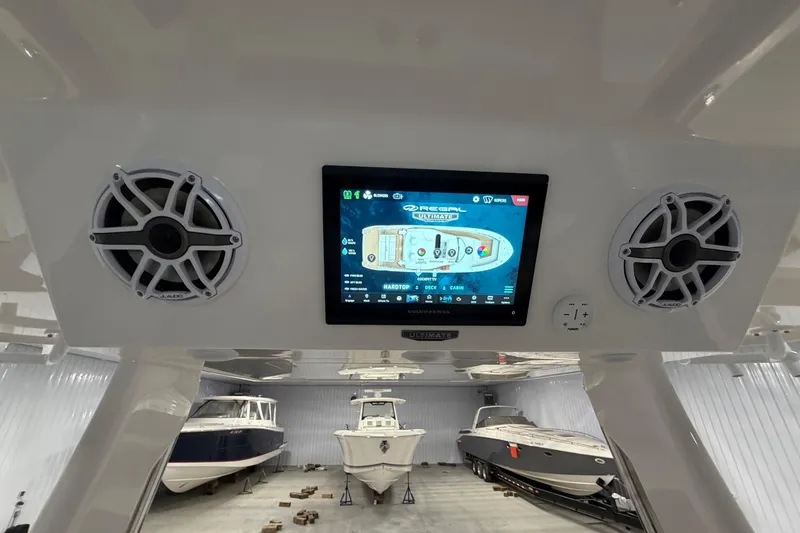 Slide: The Image of 2027 Regal 38 Surf boat dashboard with touchscreen and speakers in a storage facility. - 8