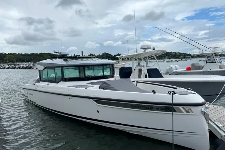 The Image of 2025 Saxdor 320 GTC boat docked in a marina under cloudy skies. - 2