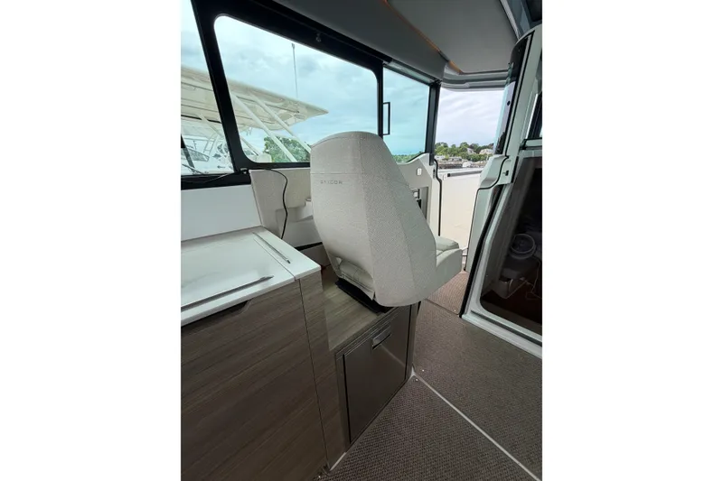 Slide: The Image of Interior of 2025 Saxdor 320 GTC boat, featuring a modern helm seat and sleek cabinetry. - 21
