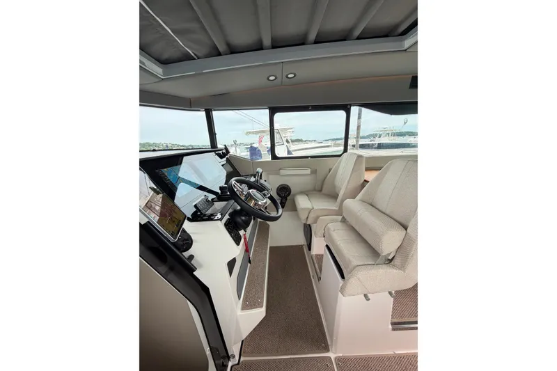 Slide: The Image of Interior of 2025 Saxdor 320 GTC boat, featuring modern helm and seating. - 24