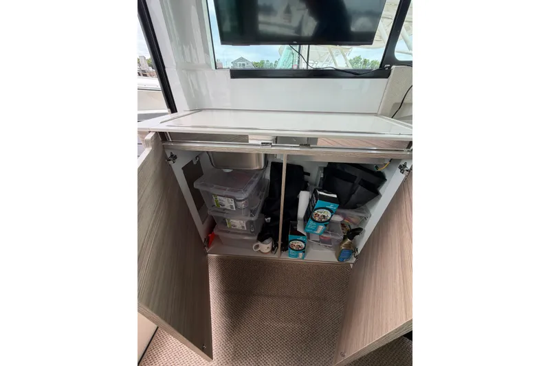 Slide: The Image of Interior storage cabinet on 2025 Saxdor 320 GTC boat, featuring organized compartments and supplies. - 20