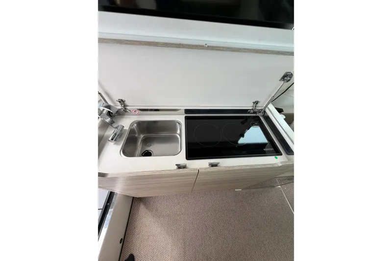 Slide: The Image of Compact kitchen area in 2025 Saxdor 320 GTC with sink and induction cooktop. - 19