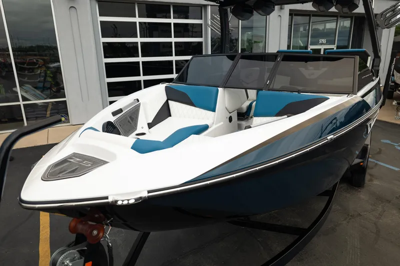 Slide: The Image of 2024 Tigé Z5 boat with sleek design, blue and white interior, parked outside a showroom. - 11