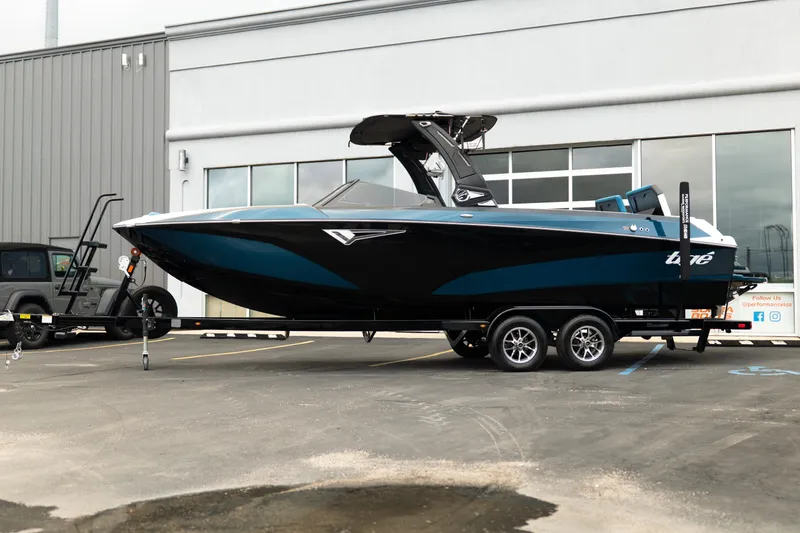Slide: The Image of 2024 Tigé Z5 boat on trailer, parked outside a modern building. - 2