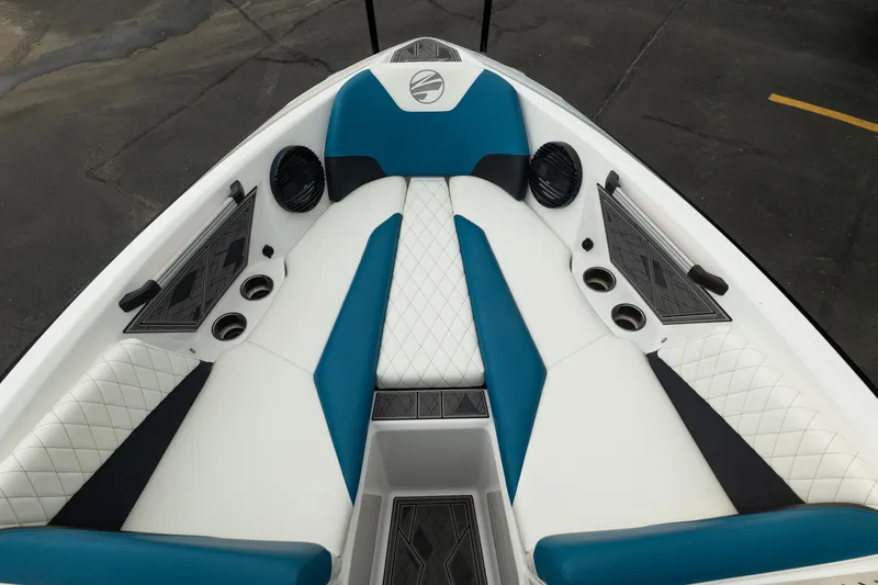 Slide: The Image of 2024 Tigé Z5 boat interior with blue and white seating, cup holders, and speakers. - 25