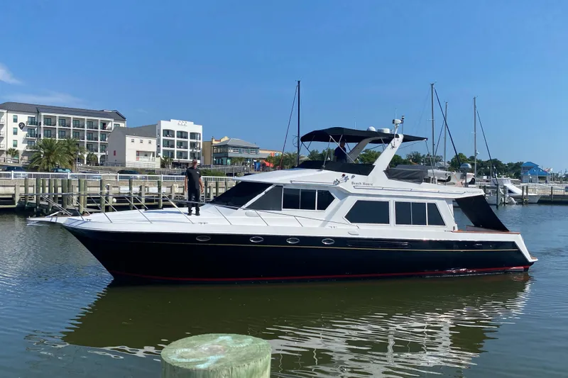 The Image of 2001 Navigator Yacht 5600 Pilothouse Classic docked in a marina under clear blue skies. - 1
