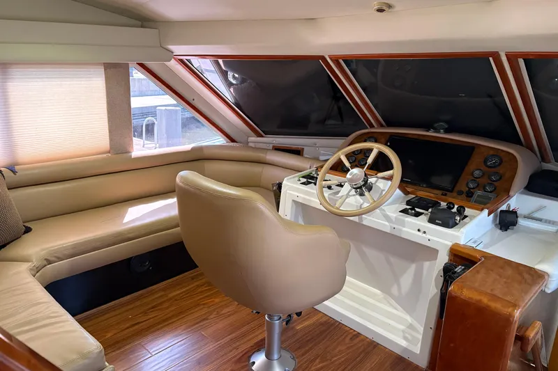 Slide: The Image of Luxurious 2001 Navigator Yacht 5600 Pilothouse Classic interior with helm and seating area. - 10