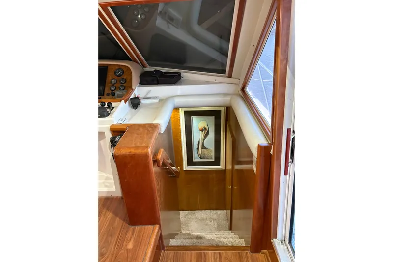 Slide: The Image of Interior of 2001 Navigator Yacht 5600 Pilothouse Classic with wooden stairs and framed artwork. - 11