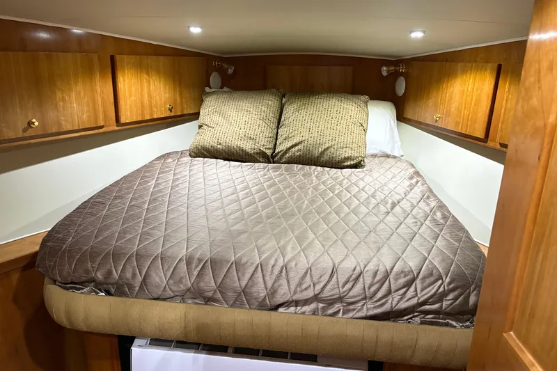 Slide: The Image of Cozy bedroom in 2001 Navigator Yacht 5600 Pilothouse Classic with wood cabinets and quilted bedding. - 17