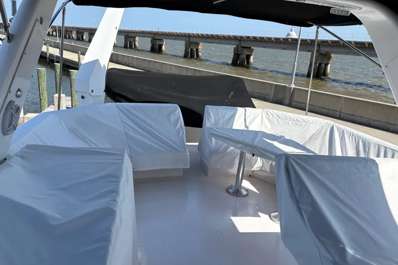 Slide: The Image of Covered seating area on 2001 Navigator Yacht 5600 Pilothouse Classic, docked near a bridge. - 18