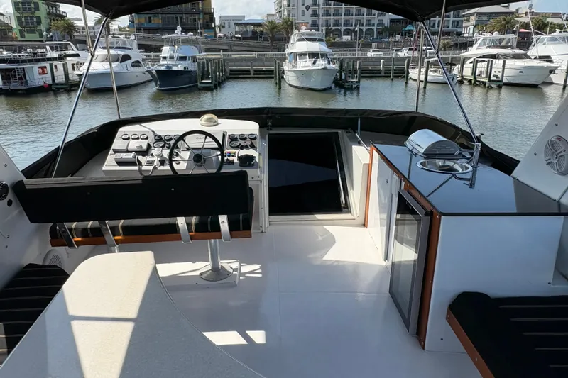Slide: The Image of 2001 Navigator Yacht 5600 Pilothouse Classic interior with helm, seating, and marina view. - 19