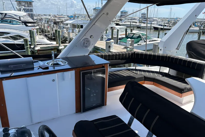 Slide: The Image of Luxurious 2001 Navigator Yacht 5600 Pilothouse Classic with sleek seating and marina view. - 23