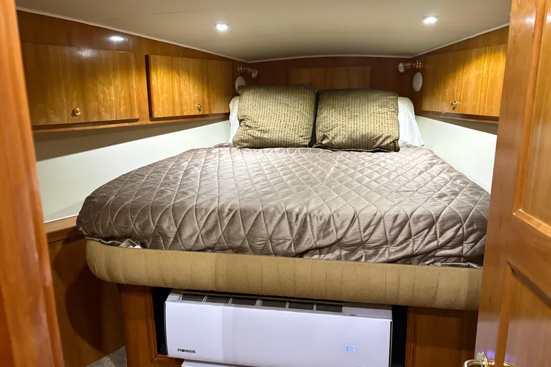 Slide: The Image of Cozy bedroom in 2001 Navigator Yacht 5600 Pilothouse Classic with wood cabinets and quilted bedding. - 28