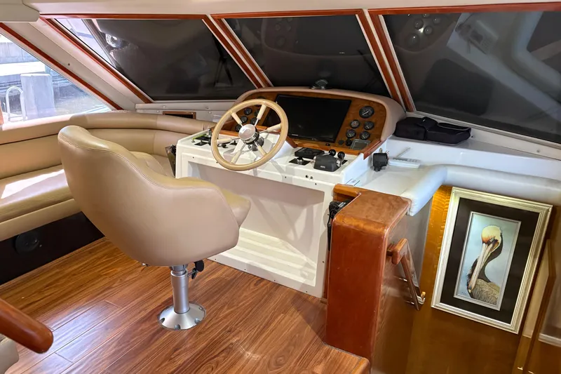 Slide: The Image of Luxurious 2001 Navigator Yacht 5600 Pilothouse Classic helm with leather seating and wood accents. - 9