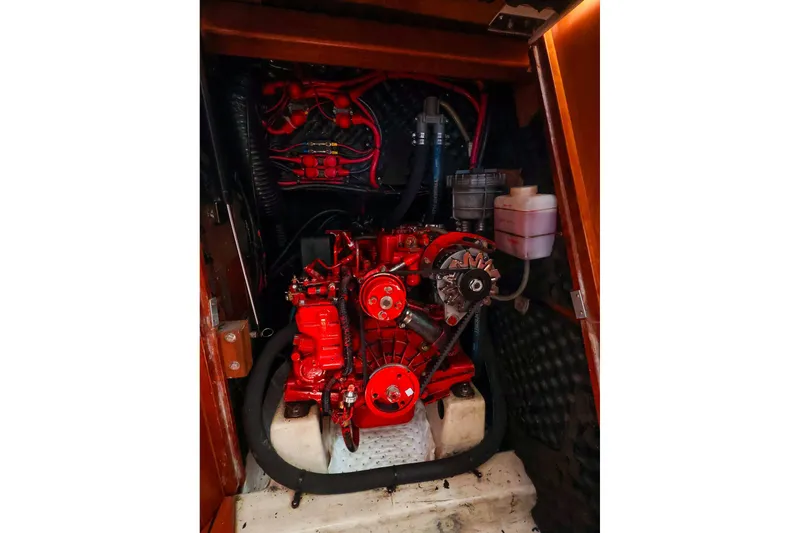 Slide: The Image of Engine compartment of a 2002 Beneteau Oceanis Clipper 361 sailboat, featuring a red engine. - 59
