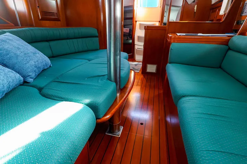 Slide: The Image of Interior of 2002 Beneteau Oceanis Clipper 361 with teal seating and wooden flooring. - 44