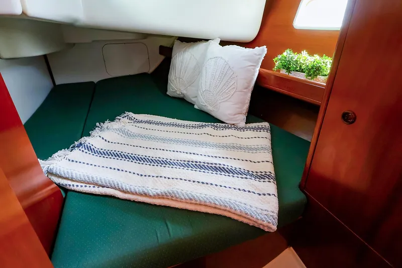 Slide: The Image of Cozy cabin interior of 2002 Beneteau Oceanis Clipper 361 with green bedding and decorative pillows. - 56