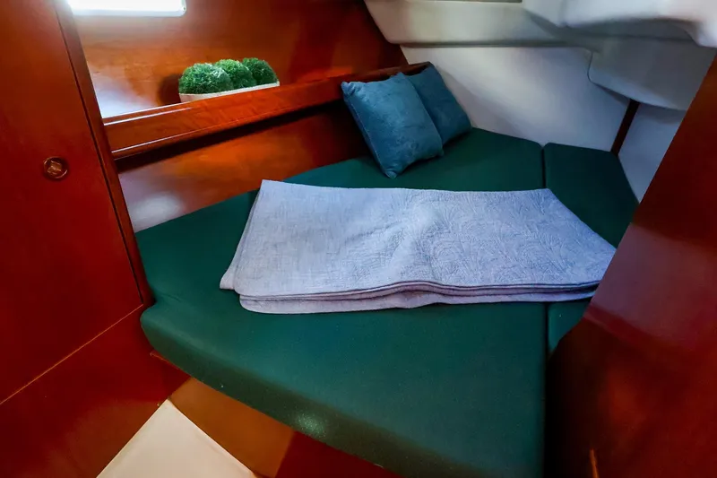 Slide: The Image of Cozy cabin interior of 2002 Beneteau Oceanis Clipper 361 with green cushions and wooden finish. - 55