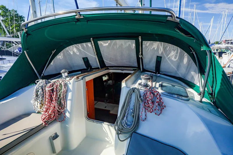 Slide: The Image of 2002 Beneteau Oceanis Clipper 361 sailboat cockpit with ropes and green canopy. - 2