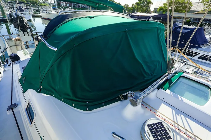 Slide: The Image of 2002 Beneteau Oceanis Clipper 361 with green canopy in marina setting. - 1