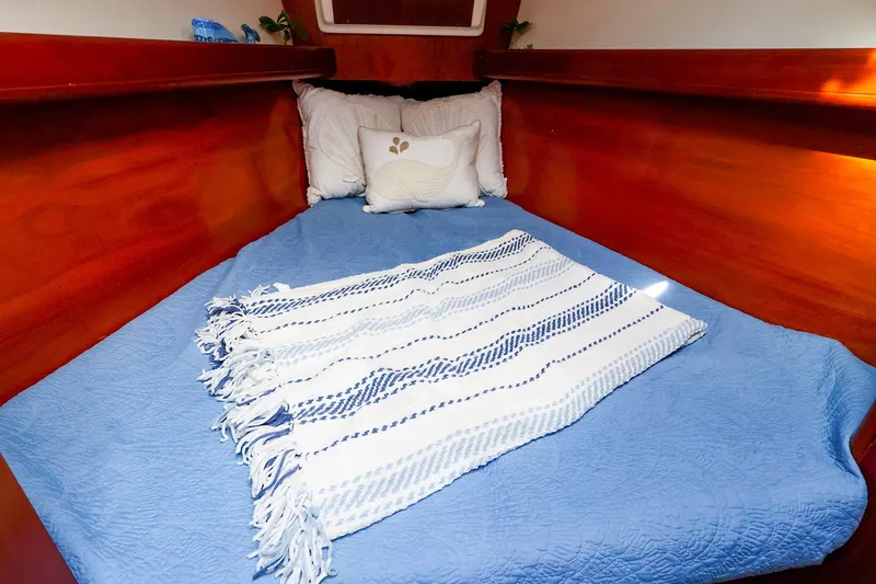 Slide: The Image of Cozy cabin interior of 2002 Beneteau Oceanis Clipper 361 with blue bedding and wooden finish. - 54
