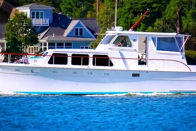 The Image of 1967 Huckins Linwood 53 yacht cruising near waterfront homes. - 0
