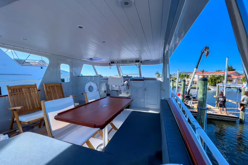 Slide: The Image of 1967 Huckins Linwood 53 yacht interior with seating and table, docked at marina. - 11