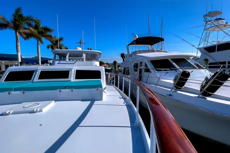 Slide: The Image of 1967 Huckins Linwood 53 yacht docked under clear blue sky with palm trees. - 9