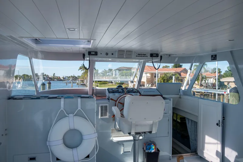 Slide: The Image of Interior view of a 1967 Huckins Linwood 53 yacht helm with waterfront background. - 8