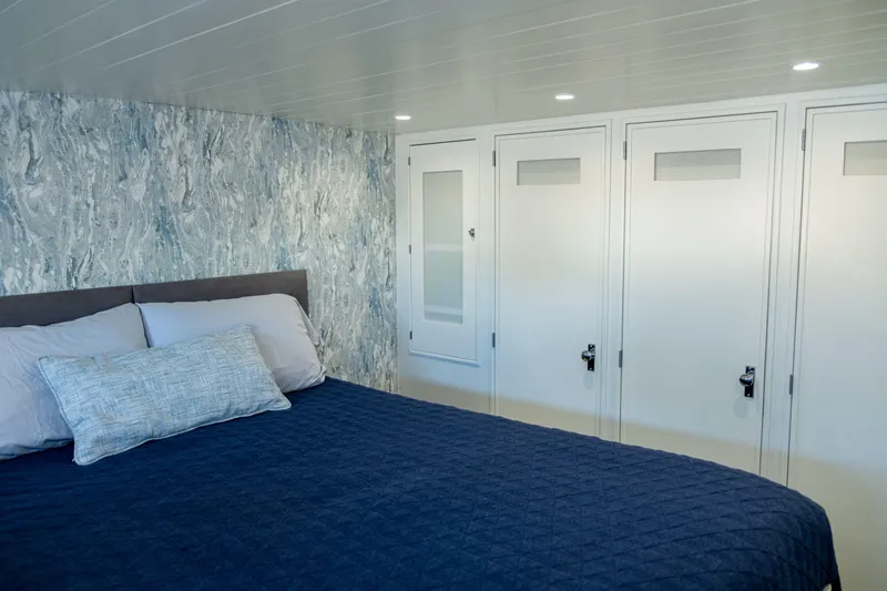 Slide: The Image of Luxurious bedroom interior on 1967 Huckins Linwood 53 yacht with blue bedding and modern decor. - 21