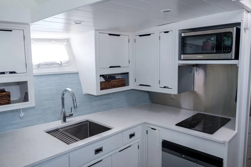 Slide: The Image of Modern kitchen interior of 1967 Huckins Linwood 53 yacht with sleek white cabinetry. - 15