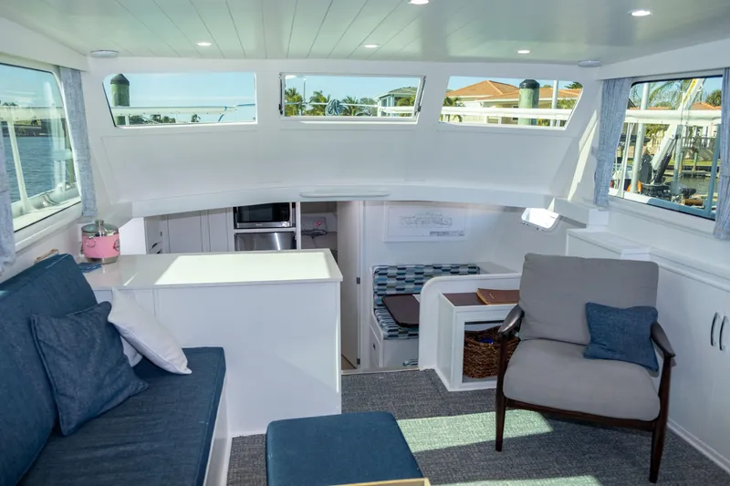 Slide: The Image of Interior of a 1967 Huckins Linwood 53 yacht, featuring modern seating and large windows. - 18