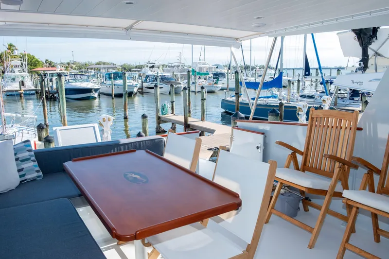 Slide: The Image of 1967 Huckins Linwood 53 yacht interior with marina view, featuring seating and wooden table. - 10