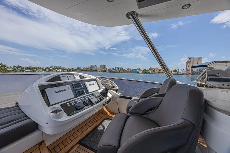 Slide: The Image of Helm of 2017 Sunseeker 75 Yacht with Simrad navigation, overlooking waterfront cityscape. - 24