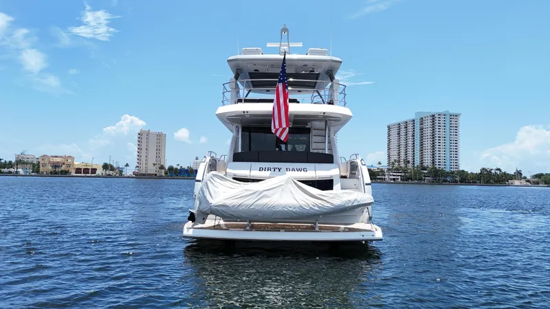 Slide: The Image of 2017 Sunseeker 75 Yacht on water, American flag, city skyline background. - 6