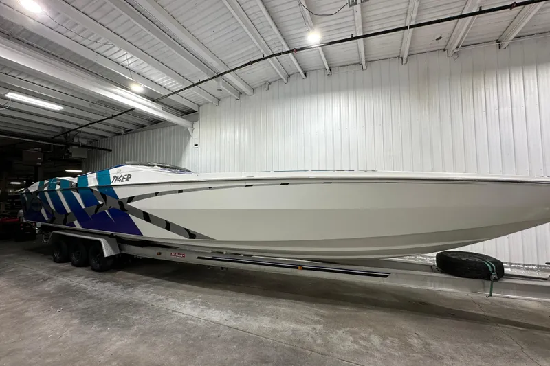 The Image of 2000 Cigarette 42' Tiger boat with blue and white design in a garage. - 0