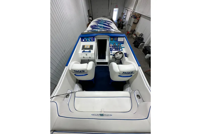 Slide: The Image of 2000 Cigarette 42' Tiger boat interior with white and blue seating, control panel, and steering wheel. - 11