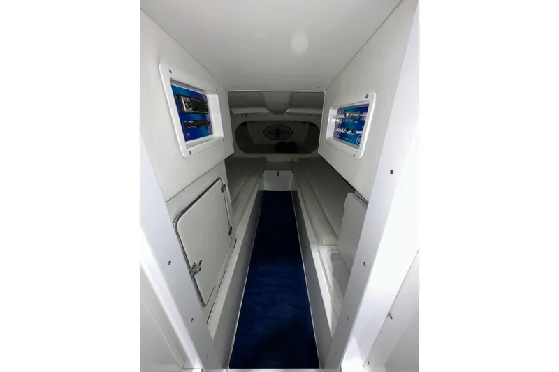 Slide: The Image of Interior cabin of a 2000 Cigarette 42' Tiger boat, featuring white walls and blue carpet. - 18